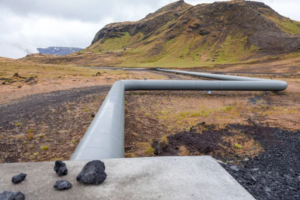 geothermal energy pipelines running along the desert hills of iceland - sustainable and clean energy concept