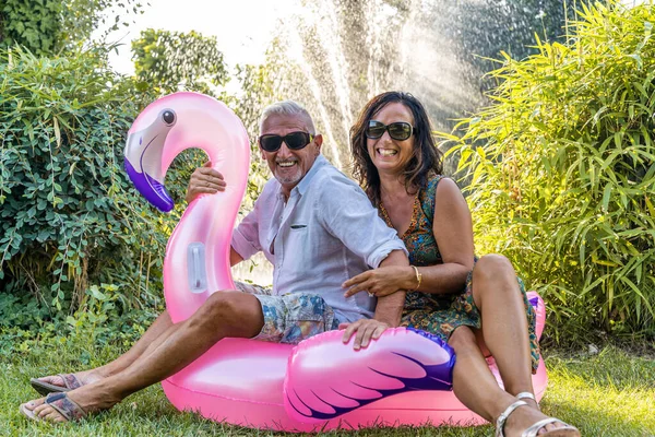 Beautiful Smiling Middle Aged Couple Having Fun Sitting Pink Flamingo — Stock Photo, Image