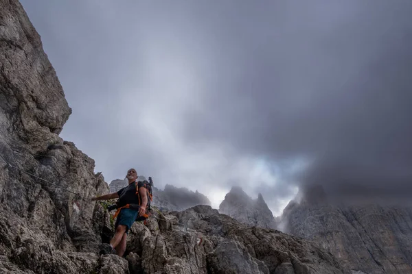 経験豊富な成熟した男性のハイカーは イタリアのドロマイトで岩の谷を登っています — ストック写真