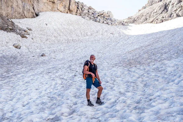 経験豊富な成熟した男性のハイカーは イタリアのドロミテの雪の谷を登っています — ストック写真