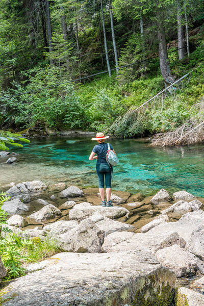 beautiful middle-aged woman having fun posing during a walk in the mountains among the pine trees