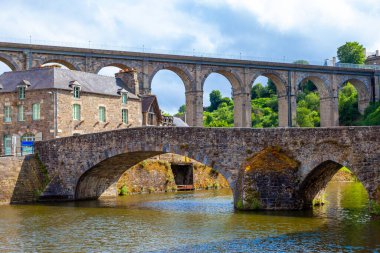 Dinan kenti Brittany Fransa limanındaki La Rance nehrine yansıyan eski taş köprü ve tarihi ortaçağ evlerinin panoramik manzarası