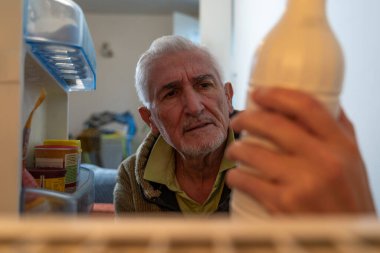 Orta yaşlı bekar bir adam buzdolabına yiyecek götürüyor. Ev aletlerinin içinden bakıyor.