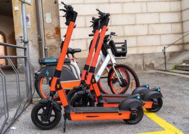 Şehirdeki kentsel park alanında elektrikli scooter ve elektrikli bisiklet kiralama hizmetleri - sürdürülebilir kentsel ulaşım kavramı