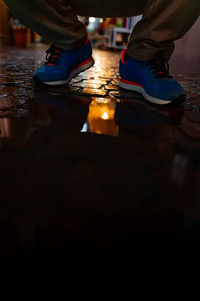 Pies Masculinos Zapatillas Azules Reflejan Charco Una Calle Ciudad Por Fotos de stock libres de derechos