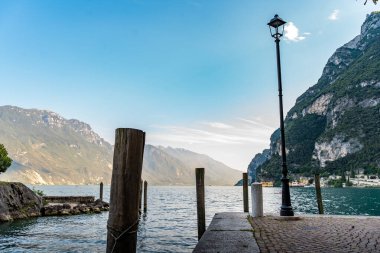 Arkasında dağlar olan Garda Gölü 'ndeki küçük bir turist limanının güzel manzarası.