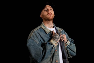 Stüdyoda siyah arka planda genç aktif rapçinin portresi