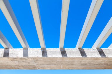 Mavi yaz gökyüzünün önünde yapım aşamasında olan beyaz beton kiriş altyapısı