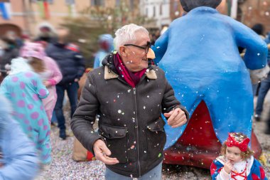 Yakışıklı orta yaşlı bir adam komik bir maske takıp selfie çekiyor. Karnaval sırasında sokakta poz veriyor.