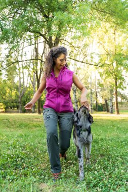 İtalyan lagorai çoban köpeğini parkta eğiten genç, güzel köpek eğitmeni.