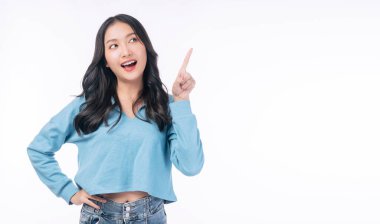 Cheerful excited asian woman use finger pointing to side with product or empty copy space standing over isolated white background. Model young girl laughing promotion. Advertisement presenting concept
