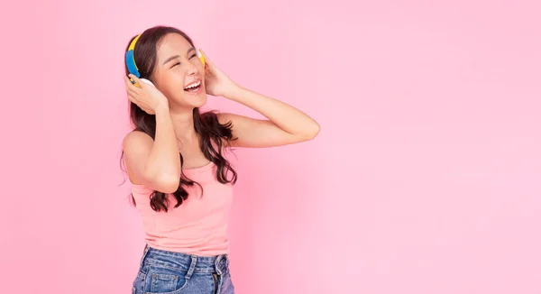 Щаслива Азіатська Жінка Носить Навушники Слухаючи Список Відтворення Стоїть Рожевому — стокове фото