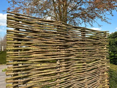 Bahçede söğüt hasır duvar var. Yatay dokuma