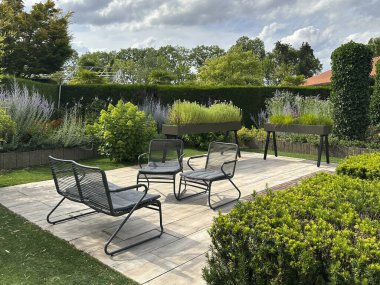 Apeltern, Hollanda, 11 Temmuz 2023, Appeltern macera bahçesi. Bahçe mobilyaları minimalist tarzda modern veranda ve bitkilerle dolu kaplar.