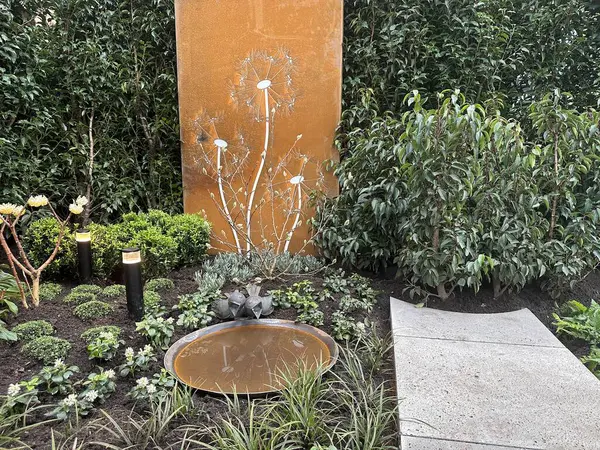 Ulft, Netherlands, March 1, 2024: Garden Fair of the East presents the latest trends and innovations in gardening. Exposition: Meditation garden with corten steel bowl and garden screen