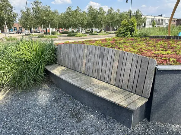 stock image Concrete and wood park bench with a green plants in the background. Green park project with innovative technology in Ulft (Netherlands)