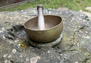 Tibet şarkı kasesi. Taş bir yüzeye yerleştirilmiş metal müzik kasesi. Rahatlama ve iyileşme titreşimleri için kullanılır. Kerfouler Bahçeleri, Fransa