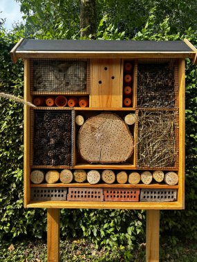 Bahçedeki arı kovanları. Arılar ve yararlı böcekler için tasarlanmış tahta böcek evi. Tahta kütükler, bambular, kozalaklar ve tuğlalardan yapılmış.