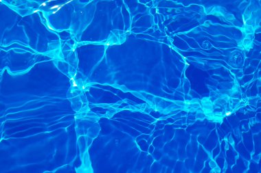 Defocus bulanık mavi şeffaf, berrak, durgun su yüzeyi dokusu sıçrama ve kabarcıklarla bulanıklaştırılmış. Moda soyut doğa geçmişi. Güneş ışığında fotokopi uzayıyla birlikte su dalgaları. Mavi suluboya parlıyor