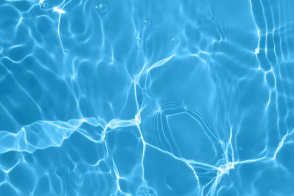 焦点がぼやけた透明ブルーの透明感のある透明感のある穏やかな水面の質感とスプラッシュと泡 傾向の抽象的な性質の背景 コピースペースと日光の水の波 青い水彩の輝き — ストック写真