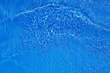 Defocus bulanık mavi şeffaf, berrak, durgun su yüzeyi dokusu sıçrama ve kabarcıklarla bulanıklaştırılmış. Moda soyut doğa geçmişi. Güneş ışığında fotokopi uzayıyla birlikte su dalgaları. Mavi suluboya parlıyor