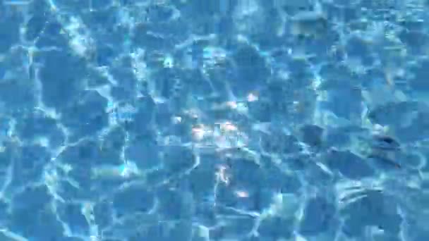 焦点がぼやけた透明ブルーの透明感のある透明感のある穏やかな水面の質感とスプラッシュと泡 傾向の抽象的な性質の背景 コピースペースと日光の水の波 青い水彩の輝き — ストック動画