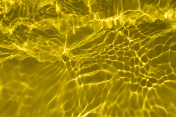 焦点は スプラッシュや泡と透明な金色の澄んだ穏やかな水の表面の質感をぼやけている 傾向の抽象的な性質の背景 コピースペースと日光の水の波 黄色の水彩画 — ストック写真
