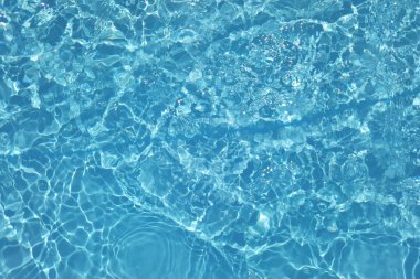 Defocus bulanık mavi şeffaf, berrak, durgun su yüzeyi dokusu sıçrama ve kabarcıklarla bulanıklaştırılmış. Moda soyut doğa geçmişi. Güneş ışığında fotokopi uzayıyla birlikte su dalgaları. Mavi suluboya parlıyor