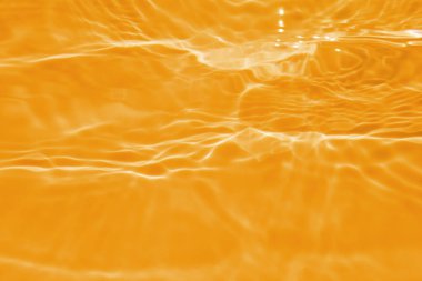 Defocus bulanık şeffaf turuncu renkte berrak durgun su yüzeyi dokusu sıçrama ve kabarcıklarla. Moda soyut doğa geçmişi. Güneş ışığında fotokopi uzayı ile su dalgası. Turuncu su damlası rengi