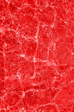 Defocus bulanık kırmızı şeffaf, berrak, durgun su yüzeyi dokusu sıçrama ve kabarcıklarla bulanıklaştırılmış. Moda soyut doğa geçmişi. Güneş ışığında fotokopi uzayıyla birlikte su dalgaları. Kırmızı suluboya parlıyor