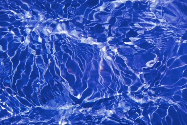 Defocus模糊了透明的蓝色清晰平静的水面纹理与水花和气泡 潮流抽象的自然背景 阳光下的水波有复制空间 蓝色水彩纹理 — 图库照片