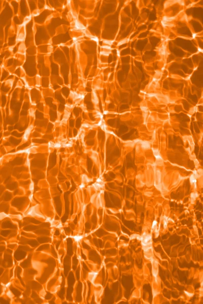透明オレンジ色の透明オレンジ色のぼやけた透明感のある穏やかな水面の質感とスプラッシュとバブル 傾向の抽象的な性質の背景 コピースペースと日光の水の波 オレンジの水滴の色 — ストック写真