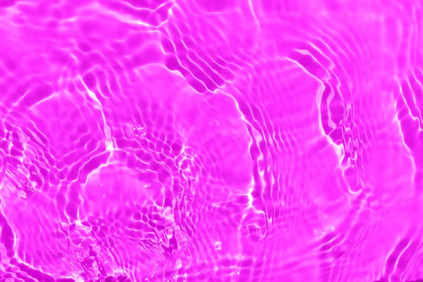 赤みを帯びた透明な紫色の透明感のある穏やかな水面の質感とスプラッシュと泡を滲ませます 傾向の抽象的な性質の背景 コピースペースと日光の水の波 ピンクの水滴が輝き — ストック写真