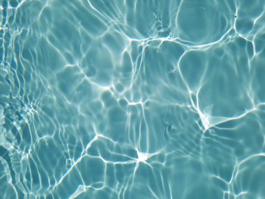 Defocus bulanık mavi şeffaf, berrak, durgun su yüzeyi dokusu sıçrama ve kabarcıklarla bulanıklaştırılmış. Moda soyut doğa geçmişi. Güneş ışığında fotokopi uzayıyla birlikte su dalgaları. Mavi suluboya parlıyor