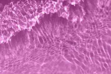 Defocus bulanık, şeffaf mor renkte berrak, durgun su yüzeyi dokusu, sıçrama, kabarcık. Parlak mor su dalgalanması arka planı. Yüzme havuzunda suyun yüzeyi. Mor köpüklü su parlıyor.