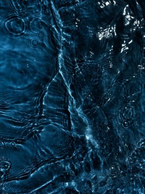 Defocus bulanık mavi şeffaf, berrak, durgun su yüzeyi dokusu sıçrama ve kabarcıklarla bulanıklaştırılmış. Moda soyut doğa geçmişi. Güneş ışığıyla birlikte su dalgaları. Mavi su parlıyor 
