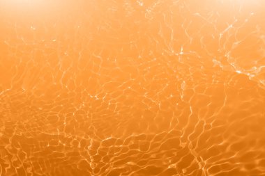 Defocus bulanık şeffaf turuncu renkli berrak sakin su yüzeyi dokusu sıçrama ve kabarcıklarla. Moda soyut doğa geçmişi. Güneş ışığında fotokopi uzayıyla birlikte su dalgaları. Kırmızı suluboya parlıyor