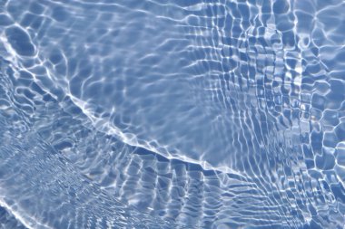 Defocus bulanık mavi şeffaf, berrak, durgun su yüzeyi dokusu sıçrama ve kabarcıklarla bulanıklaştırılmış. Moda soyut doğa geçmişi. Güneş ışığıyla birlikte su dalgaları. Mavi su parlıyor 