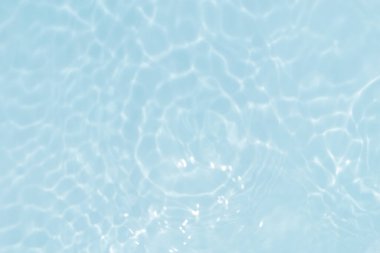 Defocus bulanık mavi şeffaf, berrak, durgun su yüzeyi dokusu sıçrama ve kabarcıklarla bulanıklaştırılmış. Moda soyut doğa geçmişi. Güneş ışığıyla birlikte su dalgaları. Mavi su parlıyor 