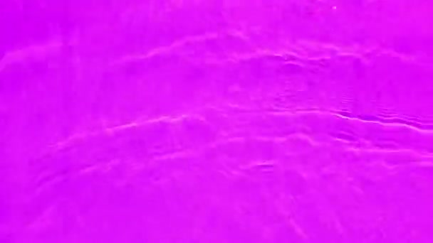 赤みを帯びた透明な紫色の透明感のある穏やかな水面の質感とスプラッシュと泡を滲ませます 傾向の抽象的な性質の背景 コピースペースと日光の水の波 ピンクの水が輝く — ストック動画