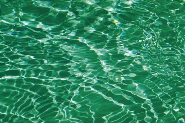 Defocus bulanık, şeffaf yeşil renkli berrak, durgun su yüzeyi dokusu sıçrama ve kabarcıklarla bulanıklaştırılmış. Moda soyut doğa geçmişi. Güneş ışığında fotokopi uzayıyla birlikte su dalgaları. Yeşil su parlıyor