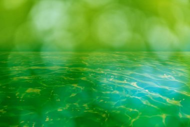 Defocus blurred transparent blue colored clear calm water surface texture with splashes and bubbles. Trendy abstract nature background. Water waves in sunlight with copy space. Blue water shine