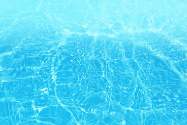 Defocus blurred transparent blue colored clear calm water surface texture with splashes and bubbles. Trendy abstract nature background. Water waves in sunlight with copy space. Blue water shine
