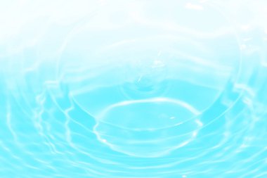 Defocus blurred transparent blue colored clear calm water surface texture with splashes and bubbles. Trendy abstract nature background. Water waves in sunlight with copy space. Blue water shine