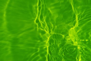 Yüzeyinde dalgalanmalar olan mavi su. Defocus bulanık mavi şeffaf, berrak, durgun su yüzeyi dokusu sıçrama ve kabarcıklarla bulanıklaştırılmış. Parlak desenli arka planda su dalgaları.