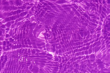 Yüzeyinde dalgalanmalar olan mor bir su. Defocus bulanık mavi şeffaf, berrak, durgun su yüzeyi dokusu sıçrama ve kabarcıklarla bulanıklaştırılmış. Parlak desenli arka planda su dalgaları.