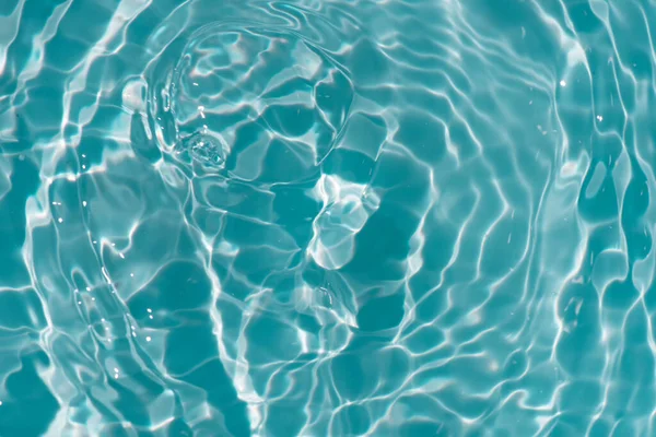 水面上有波纹的蓝色水 Defocus模糊了透明的蓝色清晰平静的水面纹理与水花和气泡 具有闪光图案纹理背景的水波 — 图库照片