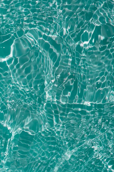 水面上有波纹的蓝色水 Defocus模糊了透明的蓝色清晰平静的水面纹理与水花和气泡 具有闪光图案纹理背景的水波 — 图库照片