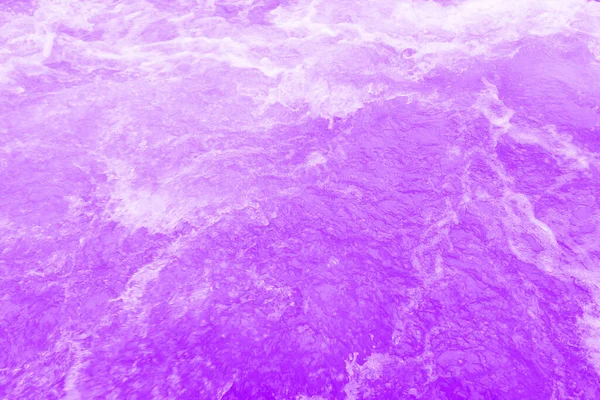 表面に波紋を持つ紫色の水 焦点がぼやけた透明ブルーの透明感のある透明感のある穏やかな水面の質感とスプラッシュと泡 輝くパターンの質感の背景を持つ水の波 — ストック写真