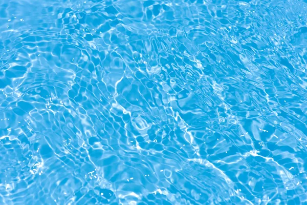 水面に波紋のある青い水 焦点がぼやけた透明ブルーの透明感のある透明感のある穏やかな水面の質感とスプラッシュと泡 輝くパターンの質感の背景を持つ水の波 — ストック写真